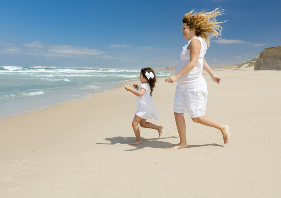 pregnant woman running next to the beach