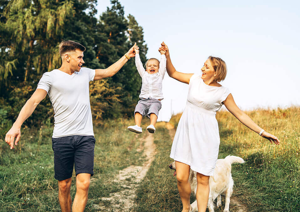 two smiling people one walking with a young boy